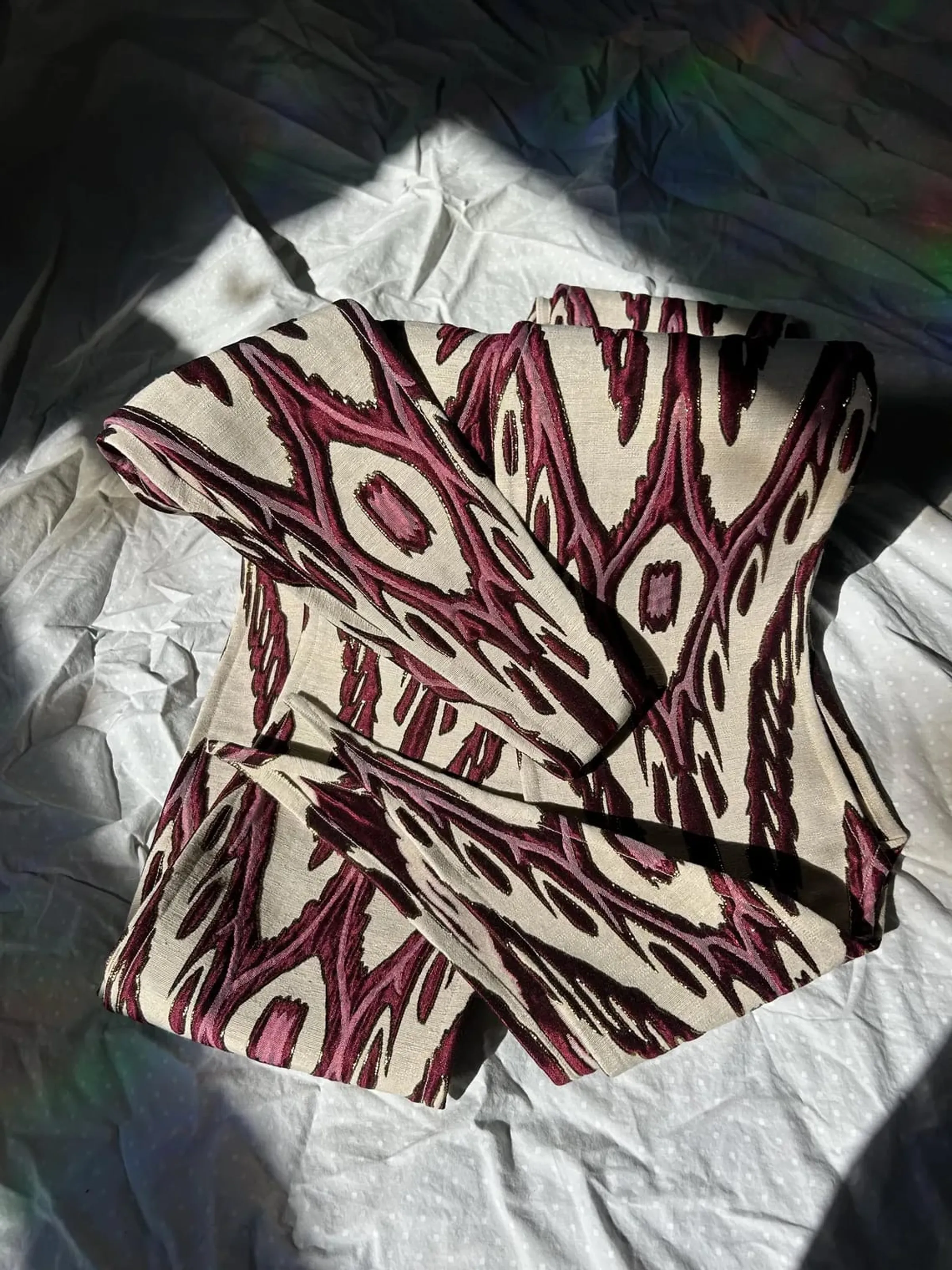Atlas ikat neck scarf folded to show the diamond ikat pattern in burgundy, cream, and gold