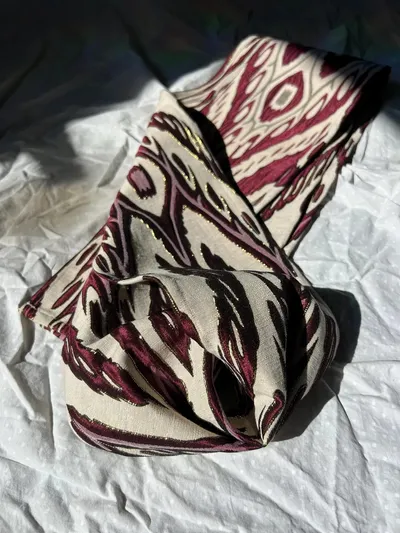 Atlas ikat neck scarf twisted into a loose knot showing the reverse side of the weave