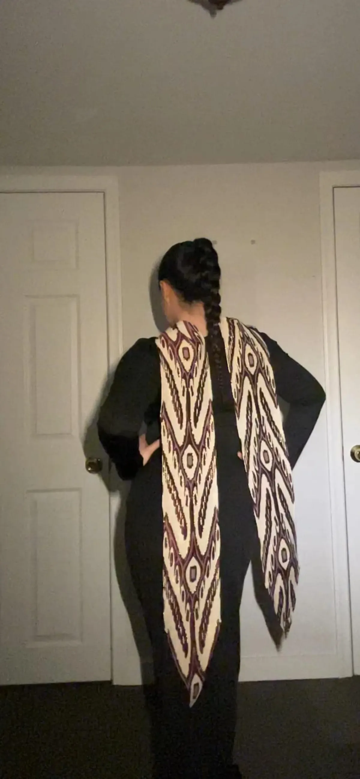 Atlas ikat neck scarf worn draped over the shoulders with hands on hips, back view