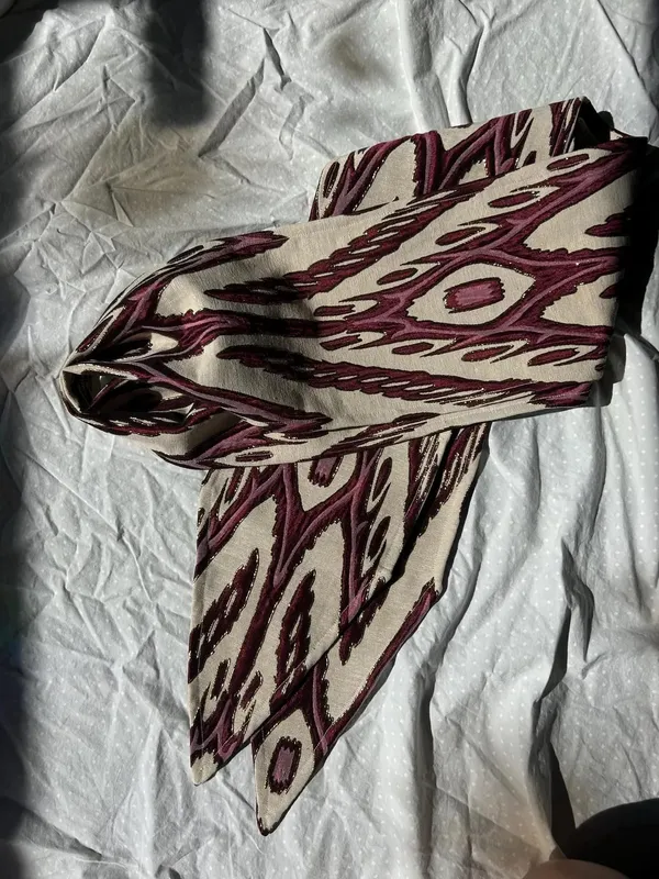 Atlas ikat neck scarf styled in a loose knot on a flat surface