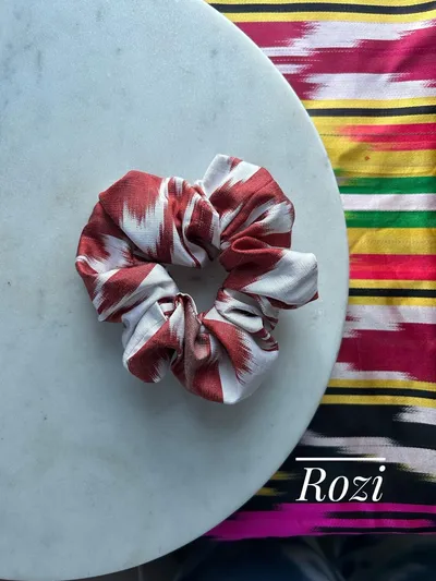 A red and white striped ikat scrunchie on a marble plate, labeled 'Rozi'