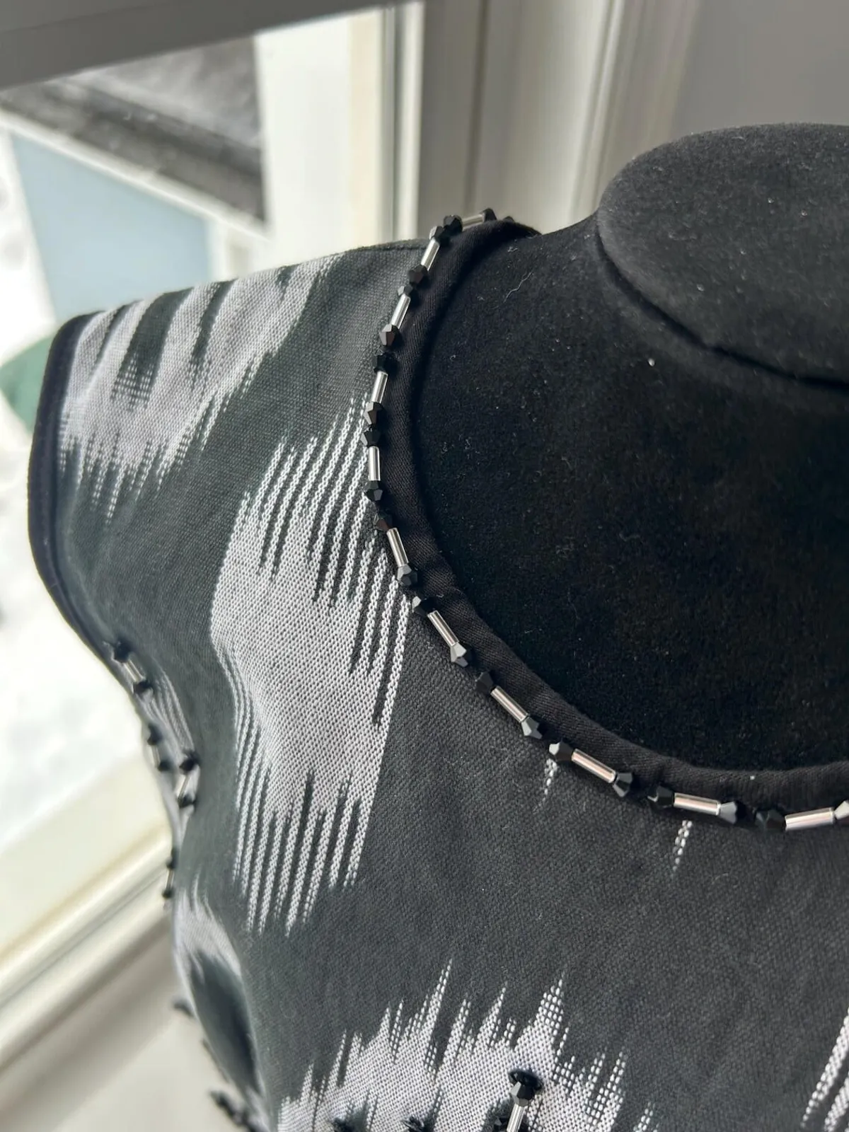 Close-up of the beaded trim along the neckline and shoulder of an atlas ikat vest