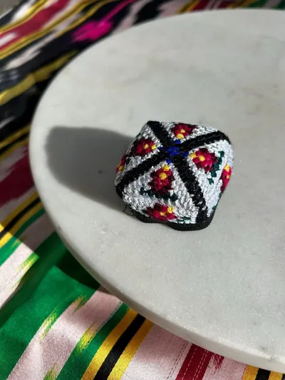 Close-up of the cross-stitch embroidery pattern on a doppi hair tie