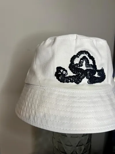 Close-up of a black sequin swirl emblem on a white bucket hat